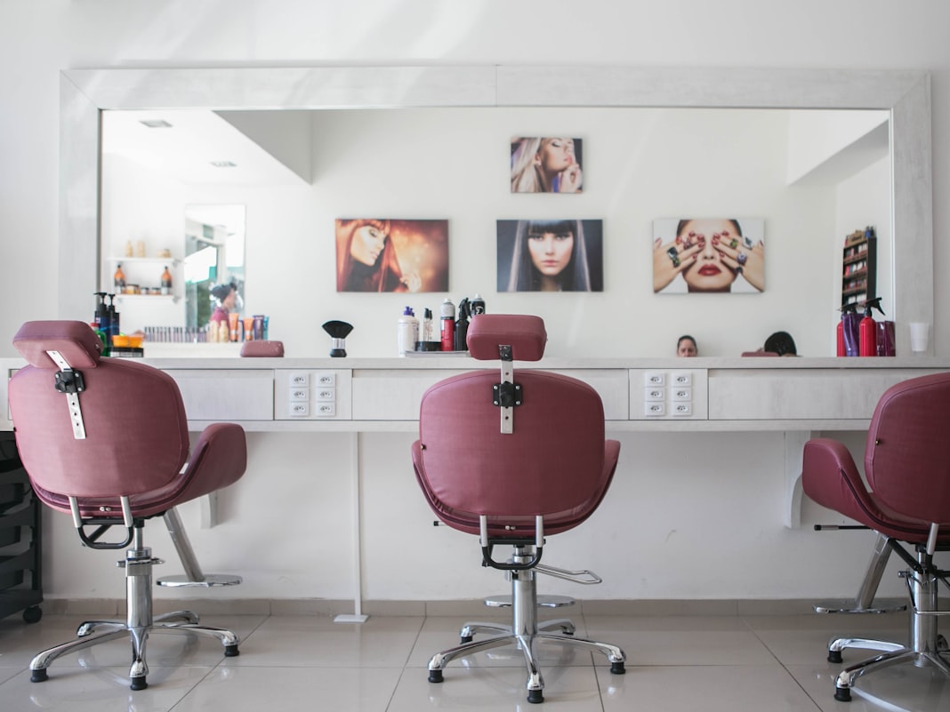 Salon styling chairs ready in front of a wide mirror