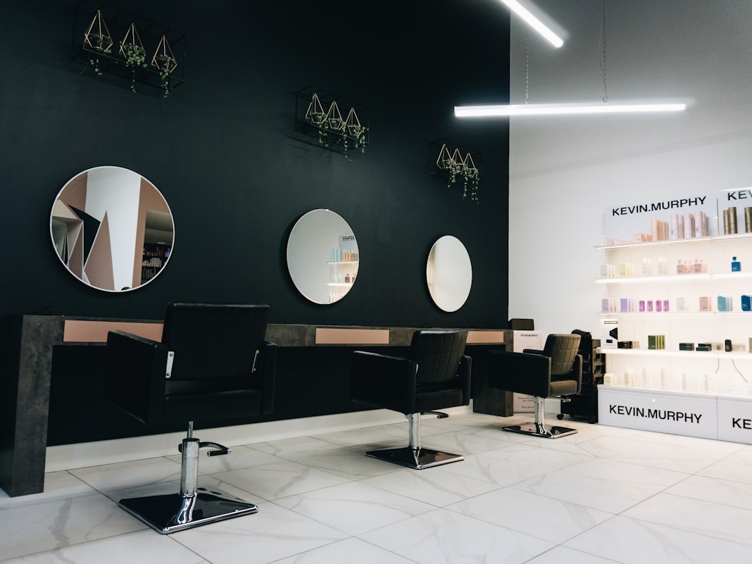 A modern salon interior with lit mirrors and styling stations