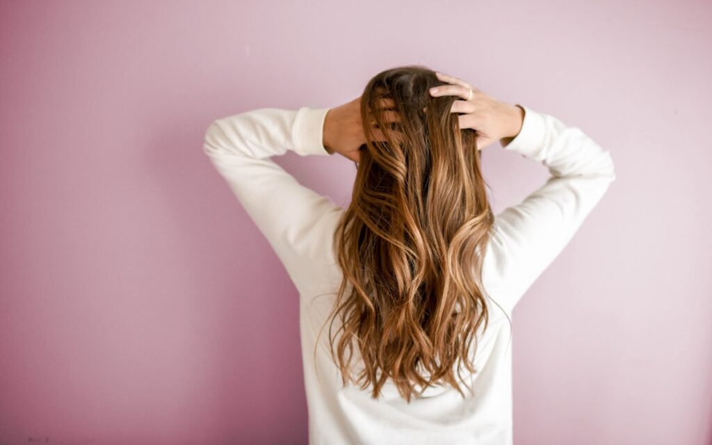 Long layered hair shown against a pink backdrop