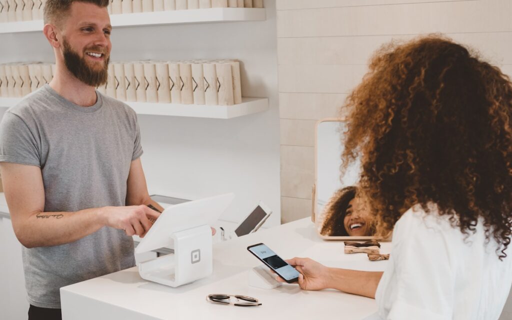Client paying by card at a salon checkout counter